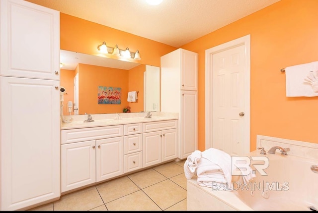 bathroom with tile patterned floors, a garden tub, double vanity, and a sink