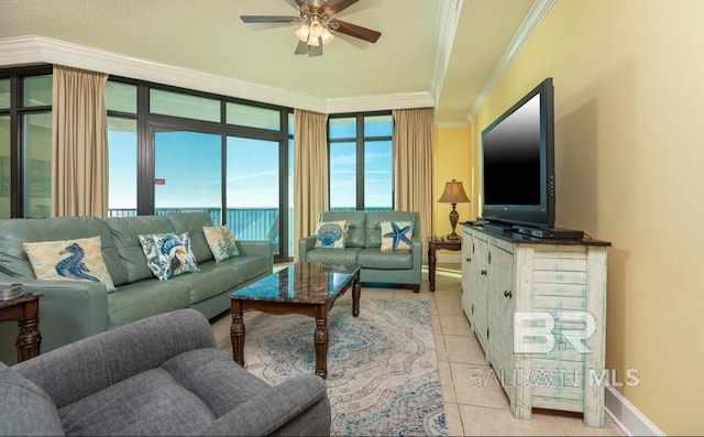 living room featuring ceiling fan, baseboards, ornamental molding, and light tile patterned flooring