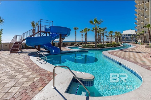 community pool with a water slide and a hot tub