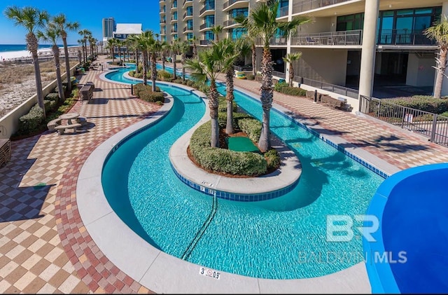 pool with a patio area and fence
