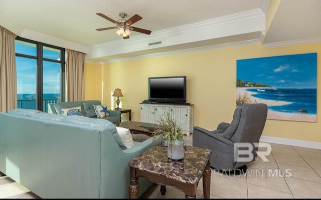 living area with baseboards, visible vents, ceiling fan, ornamental molding, and tile patterned floors