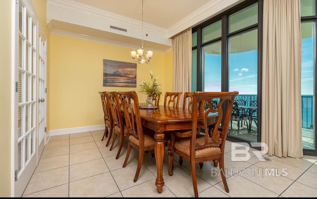 dining area featuring visible vents, ornamental molding, an inviting chandelier, light tile patterned flooring, and baseboards