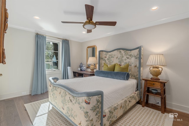 bedroom featuring light hardwood / wood-style floors, ornamental molding, and ceiling fan