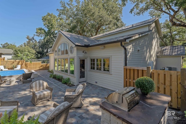 back of property with a patio and area for grilling