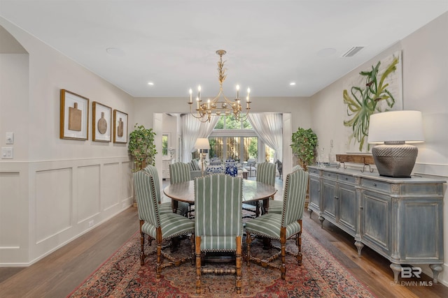 dining space featuring dark wood-type flooring and a chandelier