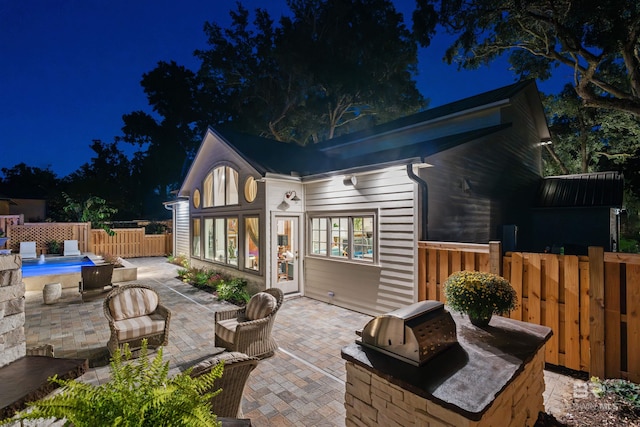 back house at twilight with a patio area