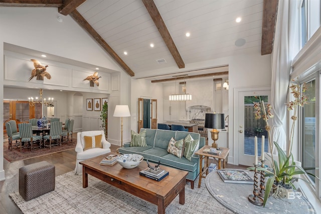 living room with high vaulted ceiling, wood-type flooring, beamed ceiling, and a chandelier