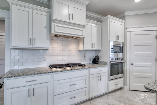 12708 Ibis Blvd, Spanish Fort, AL 36527 - kitchen featuring stainless steel appliances, tasteful backsplash, white cabinets, crown molding, and light stone countertops