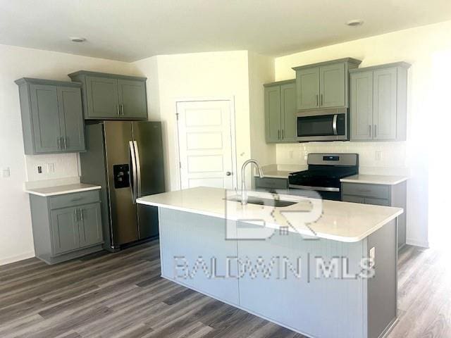 kitchen featuring an island with sink, dark wood-type flooring, sink, and stainless steel appliances