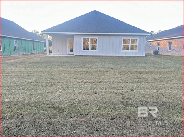 back of house with a lawn and central air condition unit