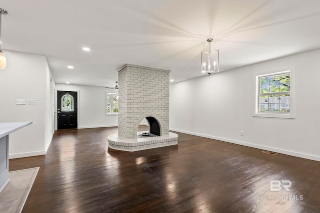 unfurnished living room with baseboards, plenty of natural light, and wood finished floors