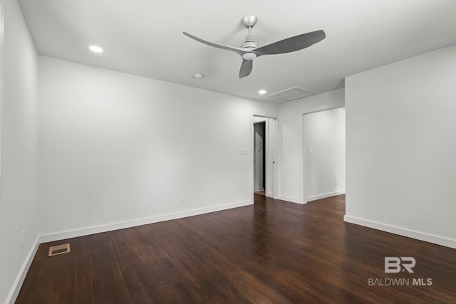 unfurnished room with baseboards, attic access, wood finished floors, and visible vents