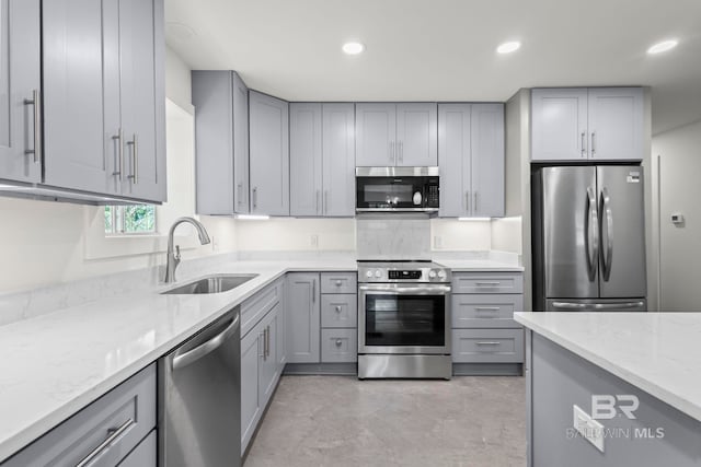 kitchen featuring a sink, gray cabinets, appliances with stainless steel finishes, and concrete floors