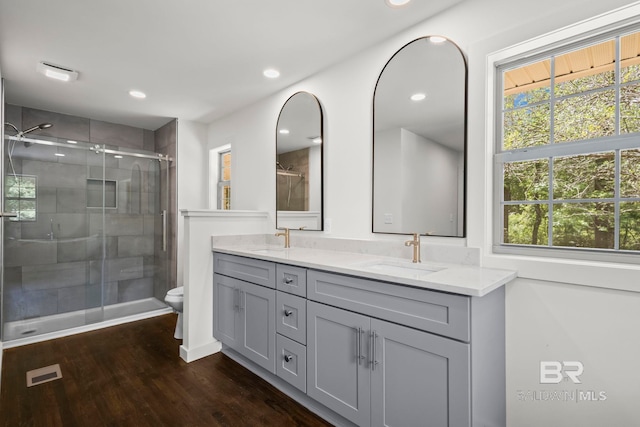 full bath featuring a sink, double vanity, wood finished floors, and visible vents