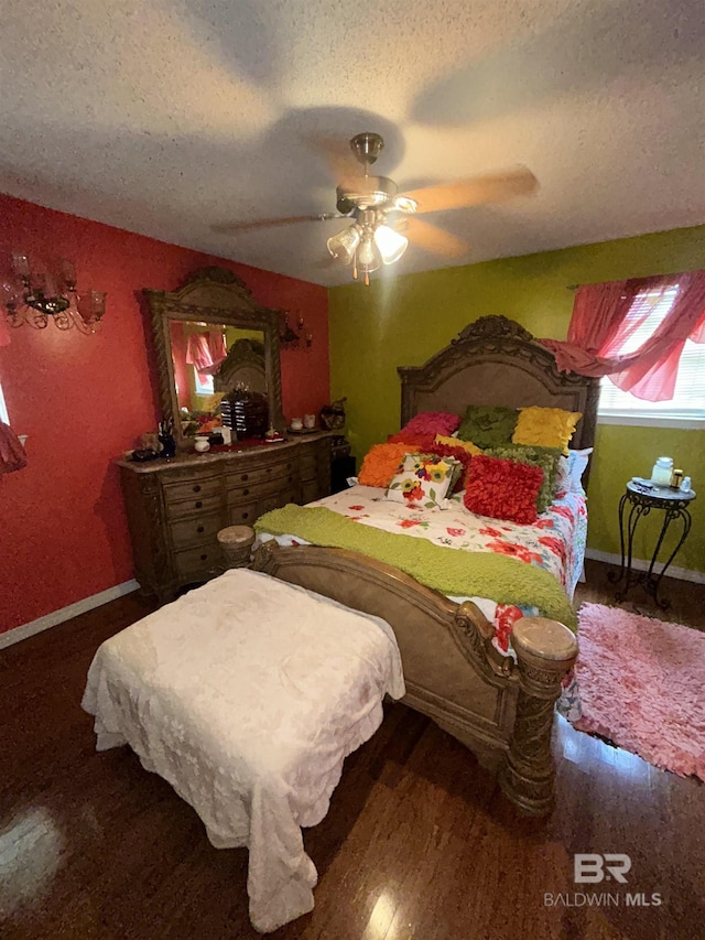bedroom featuring a textured ceiling, baseboards, wood finished floors, and ceiling fan