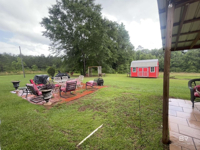 view of green lawn featuring a patio, an outbuilding, and a storage unit