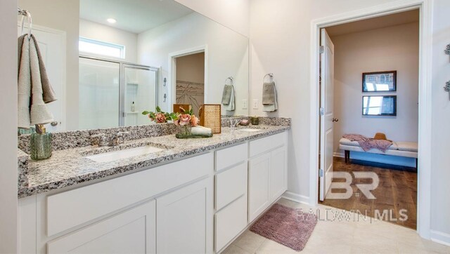 138 Preston Way, Gulf Shores, AL 36542 - bathroom with double vanity, a shower stall, baseboards, a spacious closet, and tile patterned flooring