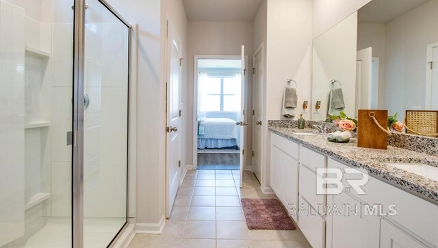 138 Preston Way, Gulf Shores, AL 36542 - ensuite bathroom featuring double vanity, tile patterned flooring, a shower stall, and baseboards