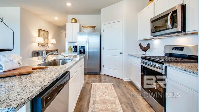 138 Preston Way, Gulf Shores, AL 36542 - kitchen featuring appliances with stainless steel finishes, a sink, recessed lighting, light wood-style floors, and white cabinetry