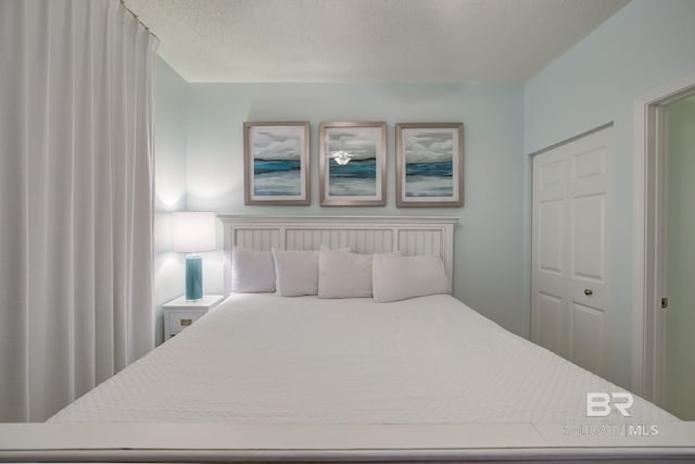 bedroom featuring a textured ceiling and a closet