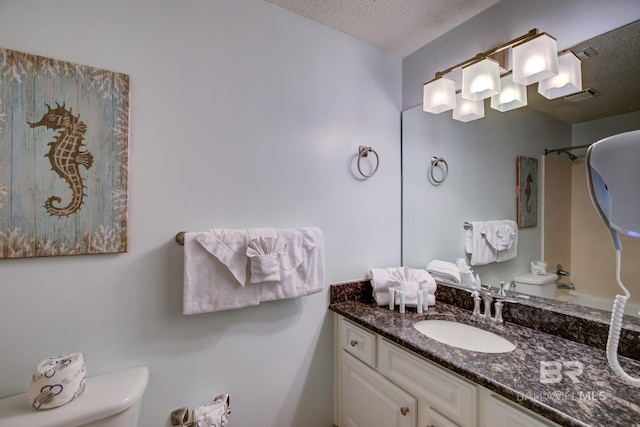 bathroom featuring vanity, a textured ceiling, and toilet