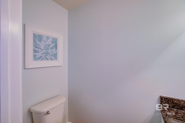 bathroom with toilet and a textured ceiling