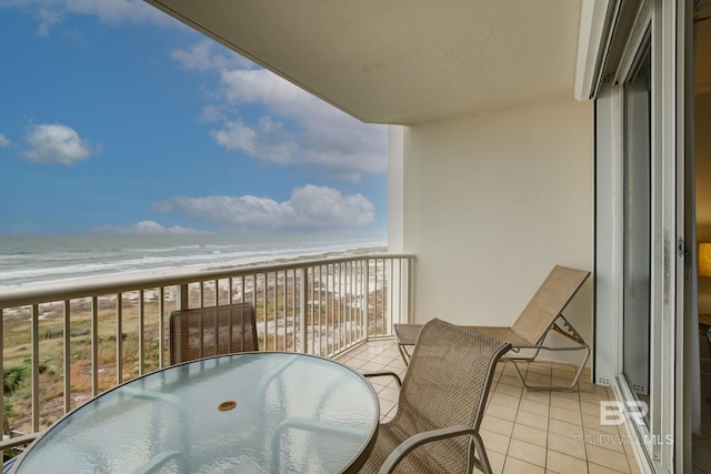 balcony with a water view and a view of the beach