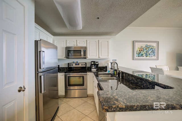 kitchen featuring kitchen peninsula, sink, white cabinets, and appliances with stainless steel finishes