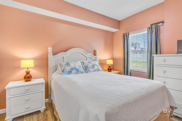 bedroom featuring baseboards and wood finished floors