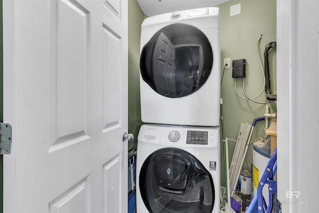 clothes washing area with stacked washer and dryer and laundry area