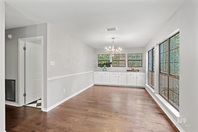 empty room featuring hardwood / wood-style floors and a chandelier