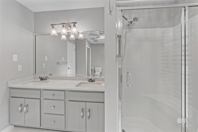 bathroom featuring a shower with door and vanity