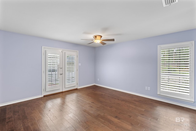 empty room with french doors, a healthy amount of sunlight, ceiling fan, and dark hardwood / wood-style floors