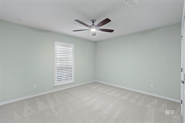 unfurnished room with a textured ceiling, ceiling fan, and light carpet