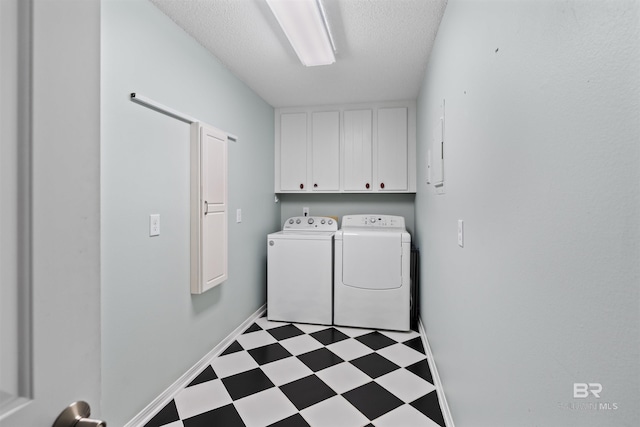 clothes washing area with cabinets, independent washer and dryer, and a textured ceiling