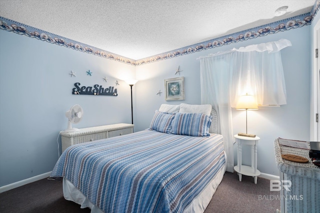 bedroom with dark colored carpet and a textured ceiling