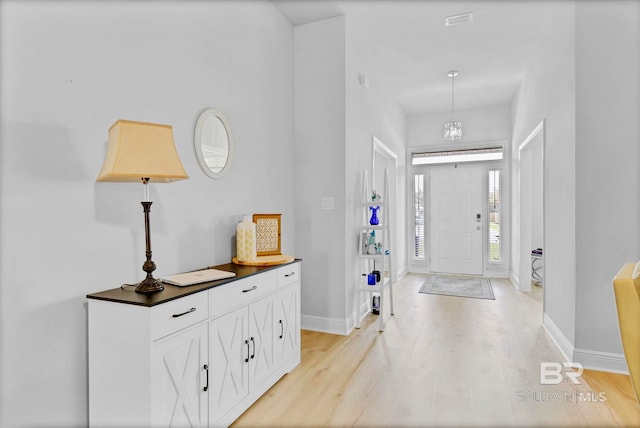 entryway featuring baseboards and light wood finished floors