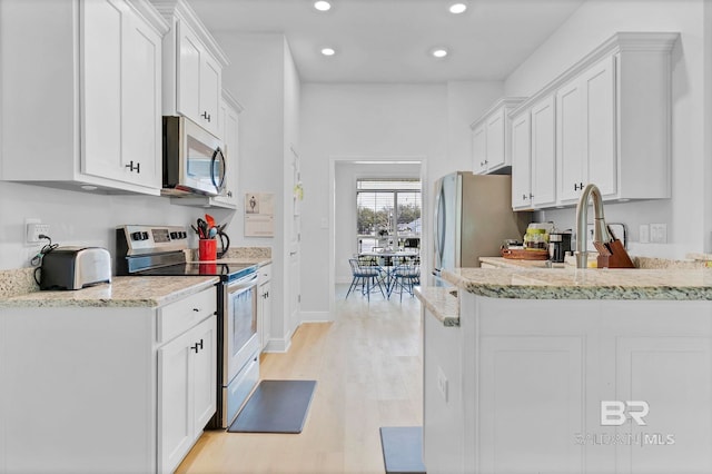 kitchen featuring white cabinetry, recessed lighting, light wood-type flooring, and stainless steel appliances