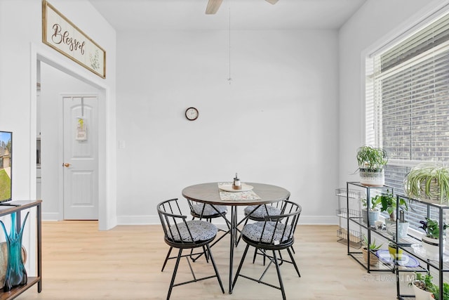 dining area with baseboards, light wood-style flooring, and a ceiling fan