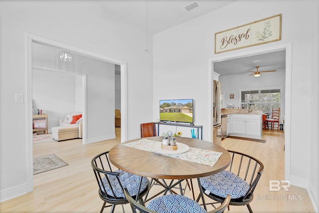 dining space with baseboards, visible vents, light wood-style flooring, and ceiling fan