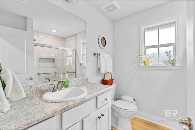 bathroom featuring visible vents, baseboards, toilet, vanity, and a stall shower