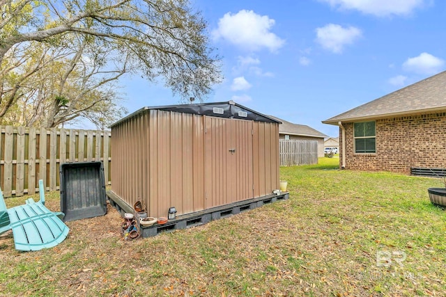 view of yard with an outdoor structure, a fenced backyard, and a storage unit