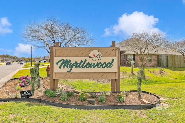 community sign featuring a lawn