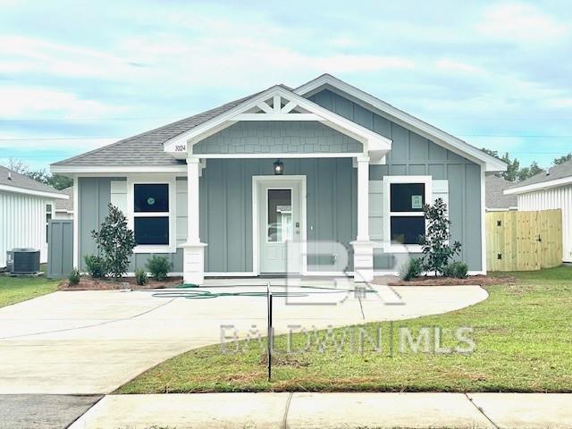 view of front facade featuring a porch, a front yard, and central AC