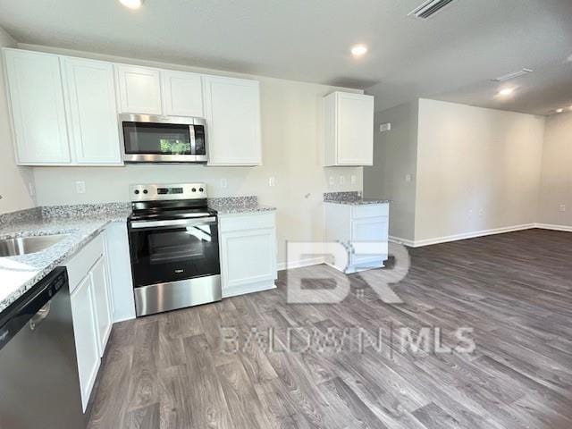 kitchen featuring white cabinets, appliances with stainless steel finishes, and dark hardwood / wood-style flooring