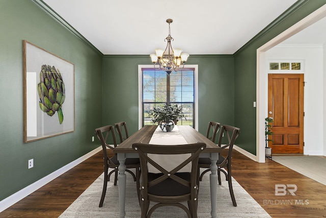 dining room with baseboards, dark wood-type flooring, crown molding, and an inviting chandelier