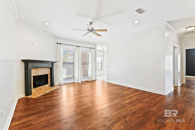 unfurnished living room featuring wood-type flooring, visible vents, crown molding, and a tiled fireplace