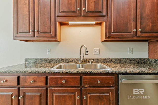 kitchen featuring dark countertops, a sink, and stainless steel dishwasher