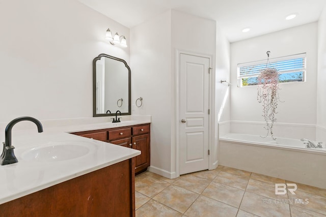 bathroom with tile patterned floors, a washtub, and vanity