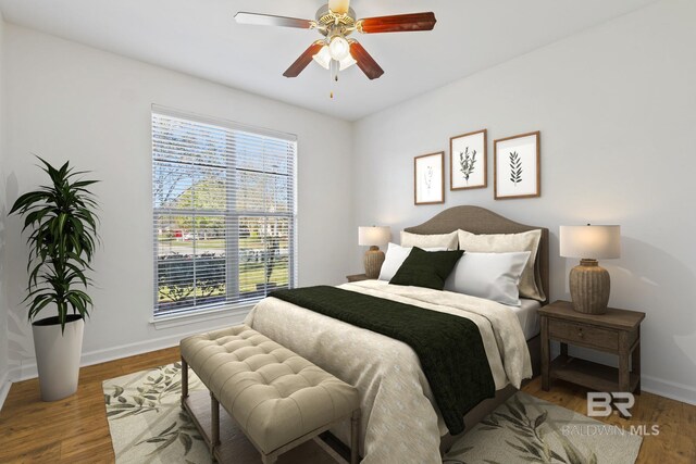 bedroom with ceiling fan, baseboards, and wood finished floors